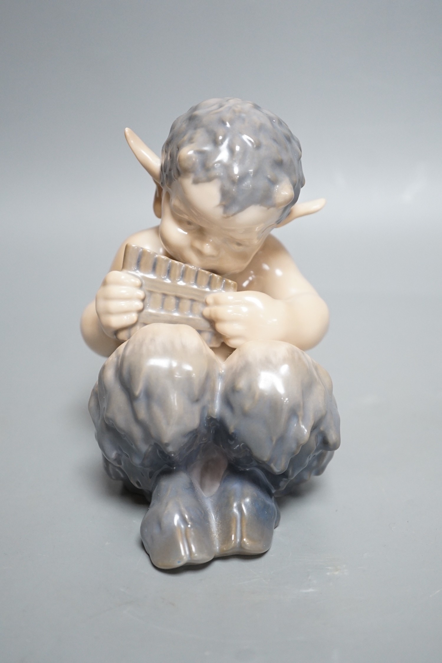 A Royal Copenhagen porcelain model of a seated faun, number 1736, 13cm tall